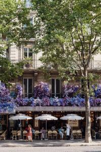 a building with tables and umbrellas in front of it at Veeve - Heavenly Elegance in Paris