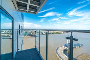 een balkon in een gebouw met uitzicht op het water bij Skyvillion - London River Thames Top Floor Apartments by Woolwich Ferry, Mins to London ExCel, O2 Arena , London City Airport with Parking in Londen