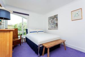 a bedroom with a bed and a desk and a window at Veeve - Canalside Comfort in London