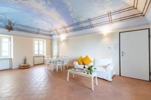 Borgo Alfieri - Elegant suites with stunning view في Magliano Alfieri: غرفة معيشة مع أريكة بيضاء وسقف