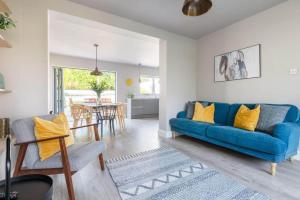 een woonkamer met een blauwe bank en een eetkamer bij The Helvellyn in Falmouth