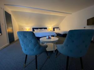 a hotel room with two beds and a table and chairs at Abbie Lodge Guest House in Weston-super-Mare