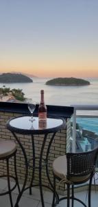 una mesa con una botella y una copa de vino en el balcón en Cobertura Duplex Vista Mar, en Mangaratiba