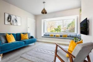 een woonkamer met een blauwe bank en een raam bij The Helvellyn in Falmouth