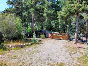 a yard with a wooden fence and trees at Maison lotissement du Bérard in Faucon-de-Barcelonnette