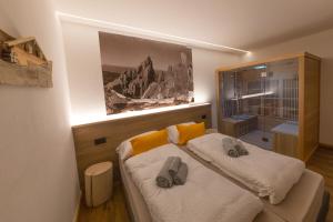 a bedroom with a bed with two slippers on it at Latemar Fiemme Apartments in Tesero