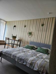 een slaapkamer met een bed en een tafel en stoelen bij LE PANORAMA studio privé avec vue magnifique TURCKHEIM TROIS ÉPIS in Turckheim