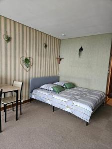 een slaapkamer met een bed en een tafel en een stoel bij LE PANORAMA studio privé avec vue magnifique TURCKHEIM TROIS ÉPIS in Turckheim