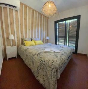 - une chambre avec un lit et un lustre dans l'établissement Maison La Plage 26, à Gujan-Mestras