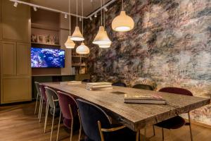 una sala de conferencias con una gran mesa de madera y sillas en Motel One Würzburg, en Würzburg