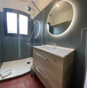 een badkamer met een wastafel en een spiegel bij Maison La Plage 26 in Gujan-Mestras