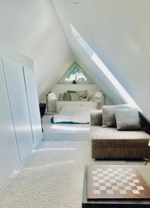 um quarto no sótão com uma cama e um sofá em Beautiful House in Blankenese em Hamburgo