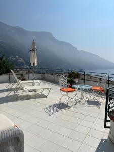 une terrasse avec des chaises, une table et un parasol dans l'établissement Positano Luxury Villas, à Positano