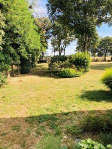 un campo de césped con árboles y arbustos en L'écrin de Chapoulier en Montoison