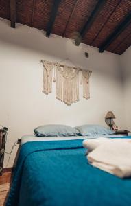 sypialnia z łóżkiem z niebieskim kocem w obiekcie Hotel Cactus Cerro w mieście Purmamarca