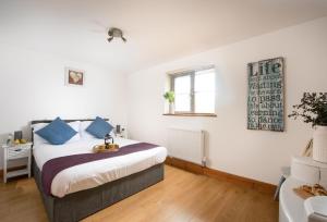 a bedroom with a bed with blue pillows at Main Beach in Redruth