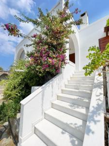 a staircase leading up to a white house with flowers at House for two!! in Angairiá