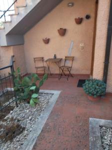 un patio con sillas y una mesa en la pared en Il Casale di Luna, en Saturnia