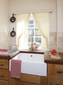 a kitchen with a white sink and a window at The Honeypot in Chipping Campden