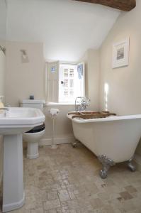 a bathroom with a tub and a sink and a toilet at The Honeypot in Chipping Campden