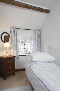 a bedroom with a bed and a window with a mirror at The Honeypot in Chipping Campden
