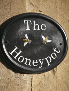 a sign that says the honeydrop with bees on it at The Honeypot in Chipping Campden