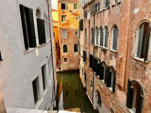 uma vista para um canal entre dois edifícios em Hotel Canada em Veneza