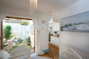a kitchen and living room with a table and chairs at Cheddar Cottage in Sidmouth