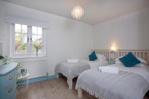 a bedroom with two beds and a window at Cheddar Cottage in Sidmouth