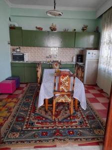 una cucina con tavolo e sedie su un tappeto di HOUSE IN LAVARA a Lávara