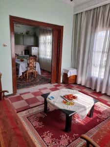 ein Wohnzimmer mit einem Tisch in der Mitte eines Zimmers in der Unterkunft HOUSE IN LAVARA in Lávara