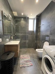 a bathroom with a toilet sink and a washing machine at Port Side Sarande in Sarandë