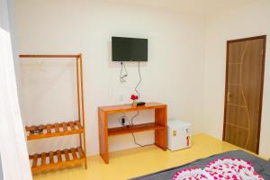 a bedroom with a bed and a tv on the wall at POUSADA VILLAGE KITE in Camocim