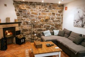 ein Wohnzimmer mit einem Sofa und einem Kamin in der Unterkunft El Ablanu Senda del Oso in Proaza