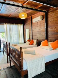 two beds in a room with wooden walls at Kaaya Eco Resort Yala in Tissamaharama