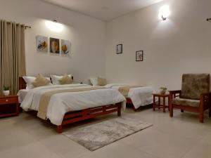 Un dormitorio con 2 camas y una silla. en The Cana's Coorg, en Ammatti