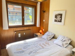 Bett in einem Zimmer mit Fenster in der Unterkunft Appartement Les Gets, 3 pièces, 6 personnes - FR-1-623-343 in Les Gets