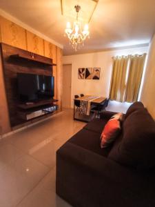 ein Wohnzimmer mit einem Sofa und einem Flachbild-TV in der Unterkunft Apartamento Aconchegante em Paulo Afonso in Paulo Afonso