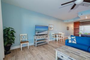 a living room with a blue couch and a table at Laketown Wharf #119 by Nautical Properties in Panama City Beach