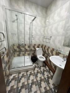a bathroom with a shower and a toilet and a sink at FIRDAVS HOTEL in Navoi