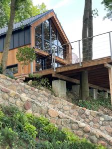 una casa di legno su una collina con un muro di pietra di Johatsu - Między niebem a rumianem a Szczupliny
