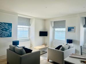 a living room with two chairs and a tv at High Tides in Lyme Regis