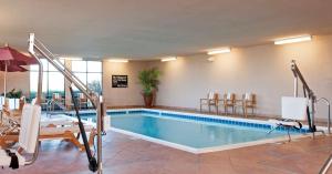 Hampton Inn & Suites Moline-Quad City Int'l Aprt في مولين: مسبح في فندق مع كراسي وطاولة