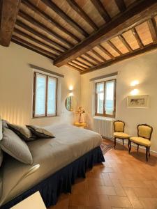 une chambre avec un grand lit et deux chaises dans l'établissement Siena UpTown - Sabrina's Lovely Apartment, à Sienne