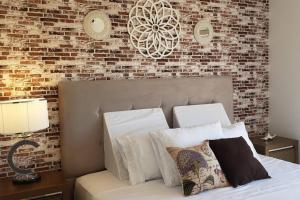 ein Schlafzimmer mit einer Ziegelwand und einem Bett mit Kissen in der Unterkunft Paz y Armonía: Con Playa Privada in Hernandarias