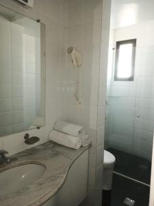 Royal Center Hotel Lourdes في بيلو هوريزونتي: حمام مع حوض وهاتف على الحائط