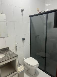 een badkamer met een toilet en een glazen douche bij Versatile Park Hotel in Ponta Porã
