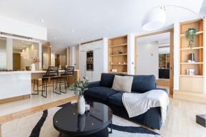 ein Wohnzimmer mit einem blauen Sofa und einer Küche in der Unterkunft My Stay Brussels - Couronne in Brüssel