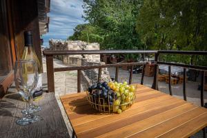 uma cesta de frutas sobre uma mesa com um copo de vinho em Къща за гости Димови em Sozopol