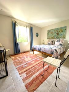 sypialnia z łóżkiem i drewnianą podłogą w obiekcie Chambre avec vue w mieście Saint-Quentin-la-Poterie